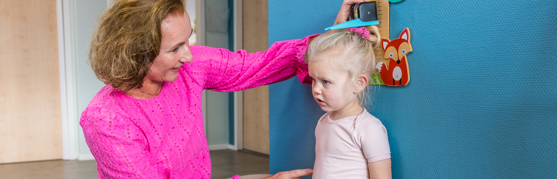 Medewerker Meet Groei Van Kind Bij Meetlat